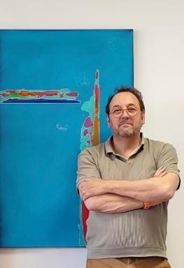 Portrait d'Alain Bulle devant l'une de ses toiles